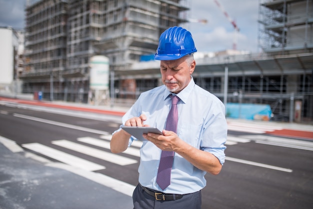 Baustellenleiter Der Sein Tablet Vor Einer Baustelle Verwendet Premium Foto