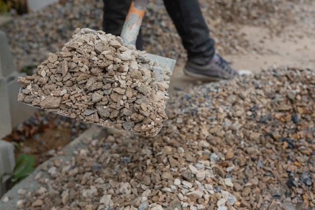 Bautechniker mischen zement, stein und sand für den bau. Kostenlose Foto