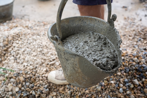 Bautechniker mischen zement, stein und sand für den bau. Kostenlose Foto
