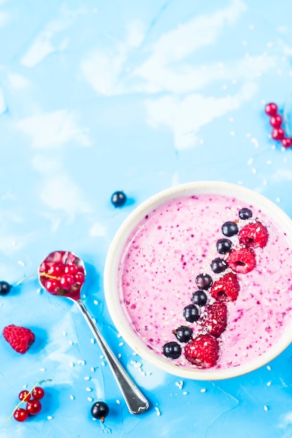 Beeren-smoothies mit johannisbeeren und himbeeren auf hellem blauem ...