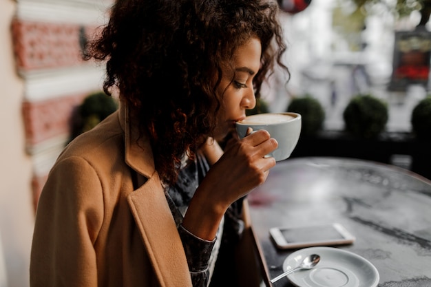 Begeisterte Dunkelhautige Hipster Frau Mit Afro Frisur Die Ihren Newsfeed Uberpruft Kostenlose Foto