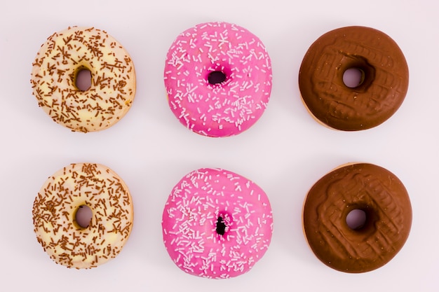 Beige; rosa und brauner donut auf weißem hintergrund Kostenlose Fotos