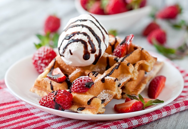 Belgien waffeln mit erdbeeren und eis auf weißem teller | Kostenlose Foto