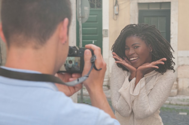 Bemannen sie das machen des fotos der lächelnden schwarzen frau in der stadt Kostenlose Fotos