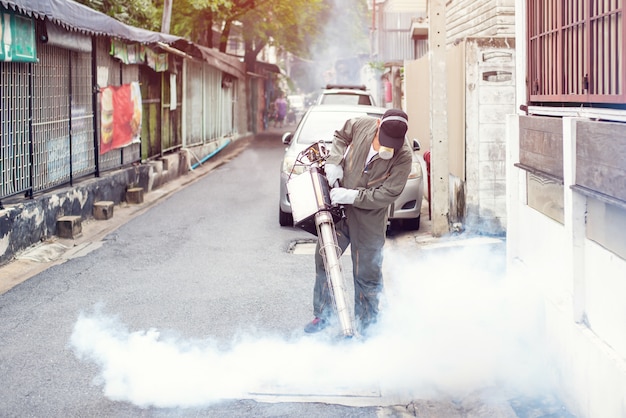 Bemannen sie die vernebelung der arbeit, um die mücke für die verhinderung der verbreitung dengue-fieber und zika-virus zu beseitigen Premium Fotos