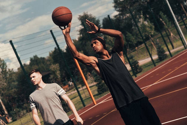 Bereit Zum Schiessen Zwei Junge Manner In Sportkleidung Spielen Basketball Wahrend Sie Zeit Im Freien Verbringen Premium Foto