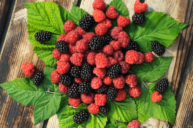 Bio frische himbeeren und brombeeren auf holztisch PremiumFoto
