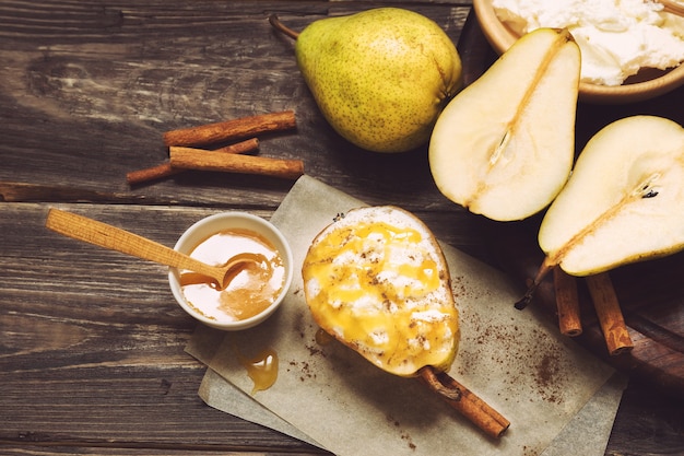 Birne mit ricotta-käse-honig und zimt auf rustikalem holzhintergrund ...