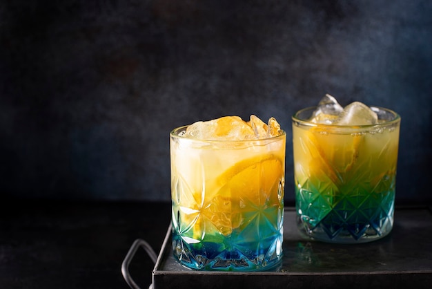 Blauer curaçao-cocktail mit orangensaft und orangenscheiben in einem ...