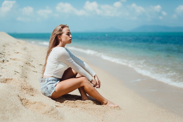 Blondes Mädchen Auf Dem Sand Am Strand Sitzen Download Der Premium Fotos 