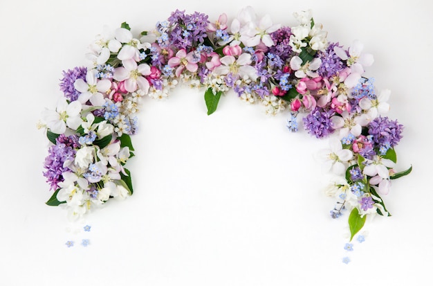 Blumen der vogelkirsche, flieder, vergissmeinnicht und apfelbäume sind mit einem bogen gesäumt Premium Fotos