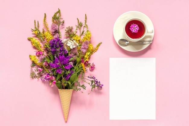 Blumenstrauss Farbige Blumen Im Eiscremewaffelkegel In Der Tasse Tee Und In Der Karte Des Leeren Papiers Premium Foto