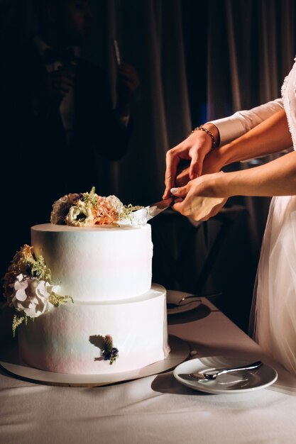 Braut Und Brautigam Schneiden Die Hochzeitstorte Weisser Kuchen Mit Frischen Blumen Dekoriert Luxus Hochzeitsdessert Premium Foto