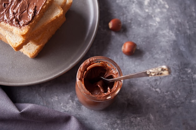 Brottoast mit schokoladencremebutter, glas schokoladencreme Premium Fotos