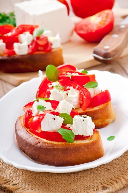 Bruschetta mit tomate, feta und basilikum | Kostenlose Foto