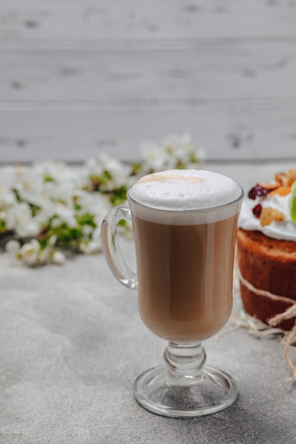 Cappuccino in einem schicken glas mit einem kuchen | Kostenlose Foto