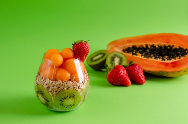 Chia-pudding mit frischen rohen tropischen früchten, hafer blättert für die gesunde ernährung auf grün ab Premium Fotos