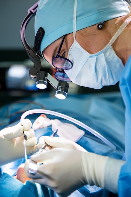 Chirurg und sein assistent, die kosmetische chirurgie auf nase im krankenhausoperationsraum durchführen. nasenumformung, augmentation. nasenkorrektur. Premium Fotos