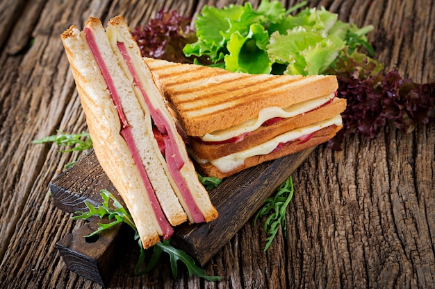 Club sandwich - panini mit schinken und käse auf holztisch. picknick ...