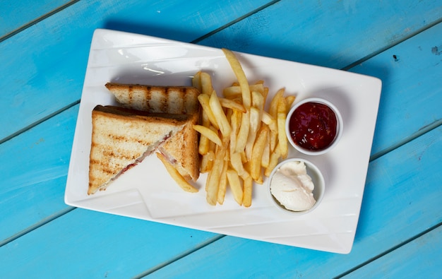 Club sandwiches mit bratkartoffeln und saucen. ansicht von oben. Kostenlose Fotos
