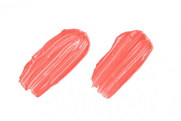 Coral make-up-muster. satz von zwei lippenstiftanschlägen in der modischen farbe lokalisiert auf weißem hintergrund Premium Fotos