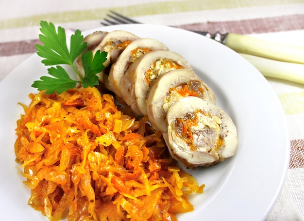 Dampfhühnerrolle mit karotte, käse und nüssen diente auf einer platte mit würzigem gedämpftem kohl Premium Fotos