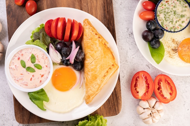 Das frühstück besteht aus brot, spiegelei, salatdressing, schwarzen ...