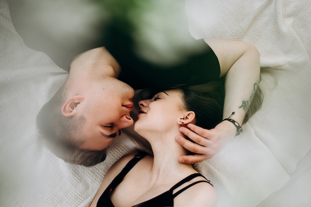 Das liebliche liebespaar liegt auf dem bett Kostenlose Foto