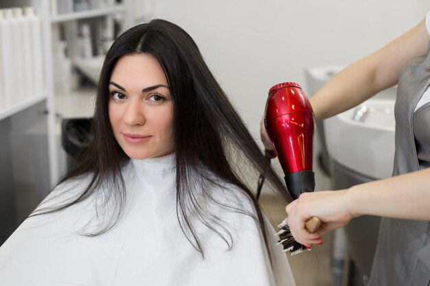 Der friseur die nassen haare der mädchen mit