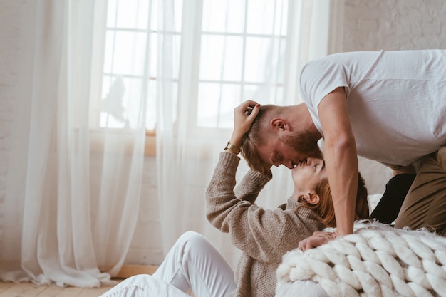 Der Mann Auf Dem Bett Küsst Eine Frau Die Auf Dem Boden Sitzt Kostenlose Foto 