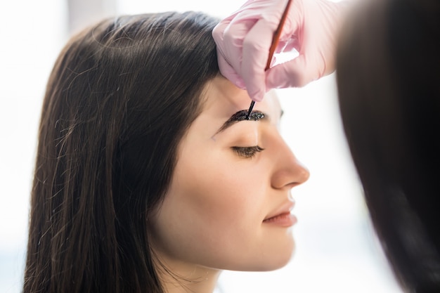 Der Meister Hat Die Augenbrauen Der Models Im Schonheitssalon Mit Schwarzer Farbe Bemalt Kostenlose Foto