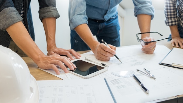 Designer im büro arbeiten diskussion blueprint architect an einem neuen projekt design draw teamwork auf schreibtisch aus holz. Premium Fotos