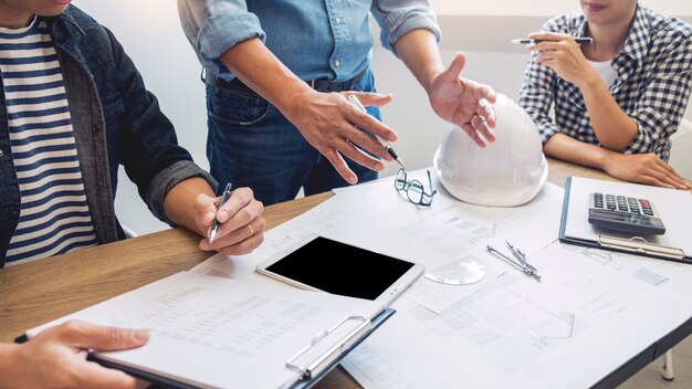 Designer im büro arbeiten diskussion blueprint architect an einem neuen projekt design draw teamwork auf schreibtisch aus holz. Premium Fotos