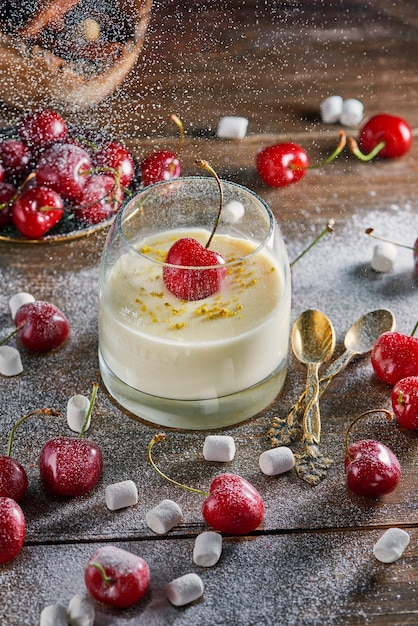 Dessert panna cotta im glas mit frischer kirsche auf holztisch ...