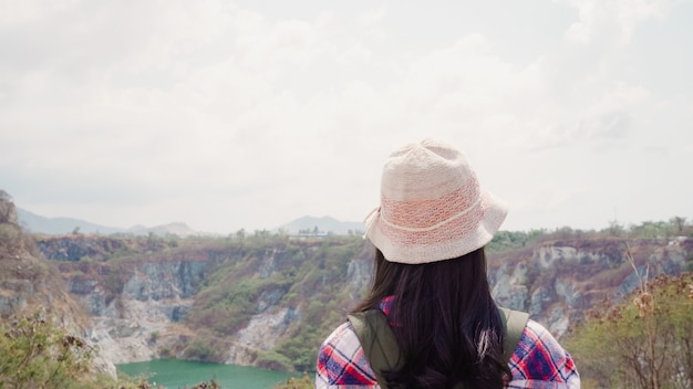Die asiatische wandererfrau des wanderers, die zur spitze des berges geht, frau genießen ihre feiertage auf dem wandernden abenteuer, das freiheit glaubt. Kostenlose Fotos