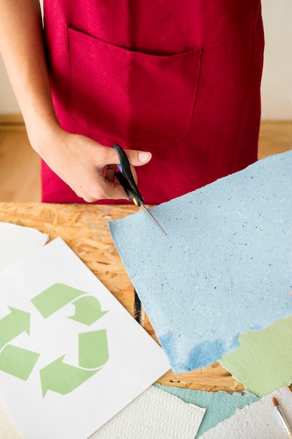 Die Hand Der Frau Die Blaues Papier Mit Scheren Schneidet Kostenlose Foto