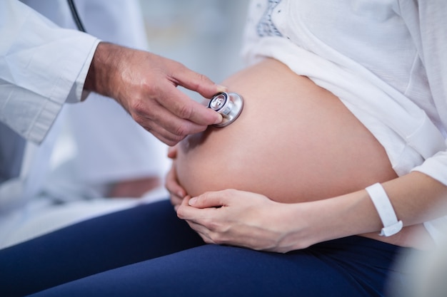 Doktor Der Den Bauch Der Schwangeren Frau Mit Stethoskop In Der Abteilung Untersucht Premium Foto 