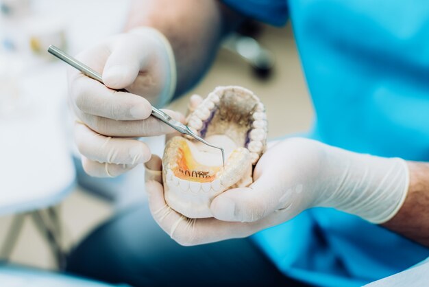 Doktor kieferorthopäde zeigte, wie die platte funktioniert, um zähne auf den kiefern flach zu drücken Premium Fotos
