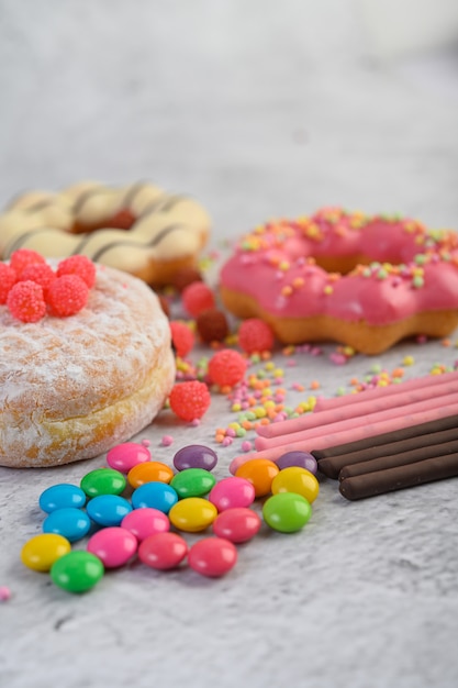 Donuts mit puderzucker und süßigkeiten auf einer weißen oberfläche ...