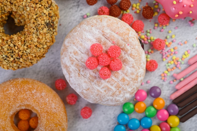 Donuts mit puderzucker und süßigkeiten auf einer weißen oberfläche ...