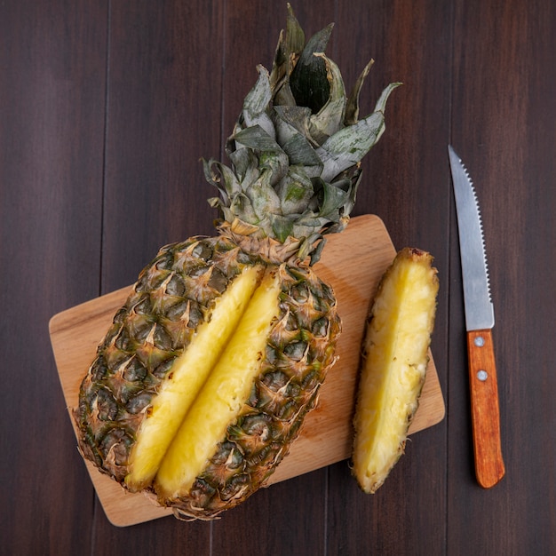 Draufsicht auf ananas mit einem stück aus ganzen früchten auf ...