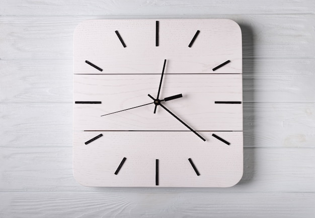 Draufsicht der hölzernen uhr mit heraus uhrzeigern, setzen zeit kein zeitkonzept, hölzerner schreibtischraum, um die kopienbenennung zu setzen und schaffen ihre zeit mit es sei denn zeitkonzept Premium Fotos