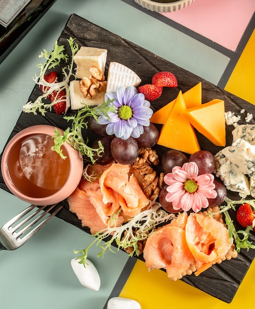 Draufsicht Der Kaseplatte Mit Gerauchertem Lachs Blauschimmelkase Cheddar Traube Und Blumen Kostenlose Foto