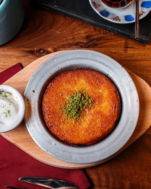 Draufsicht Des Traditionellen Turkischen Nachtisch Kunefe Mit Pistazienpulver Auf Einem Holztisch Kostenlose Foto