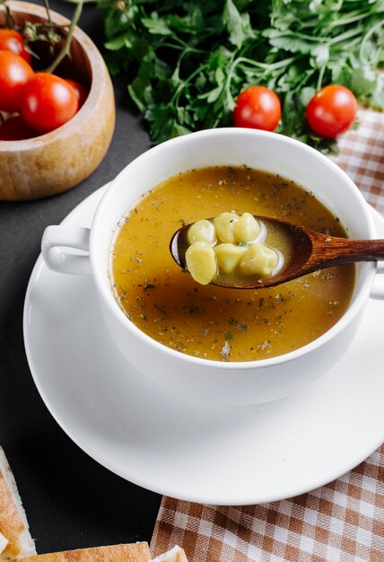 Dushbara traditionelle suppe serviert mit kräutern und tomaten auf dem ...