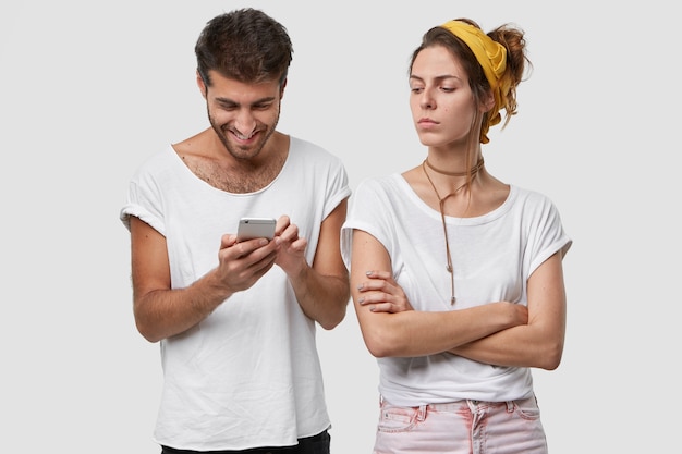 Eifersuchtige Frau Halt Die Arme Verschrankt Schaut Ehemann Mit Missfallenem Gesichtsausdruck An Der Sie Ignoriert Online Spiele Auf Dem Handy Spielt Mit Freunden Chattet Kostenlose Foto