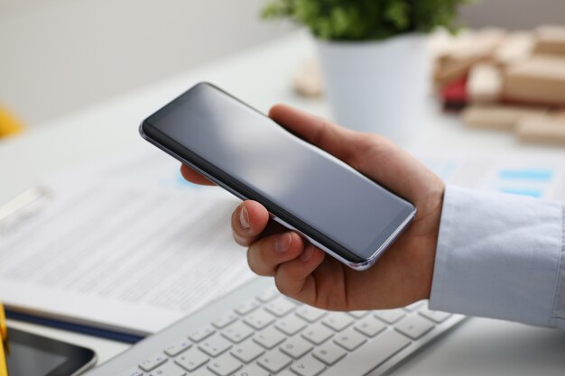 Ein geschäftsmann hält ein neues smartphone in der hand der markt für