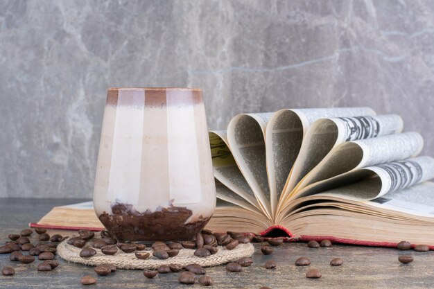 Ein glas milch mit buch und kaffeebohnen auf