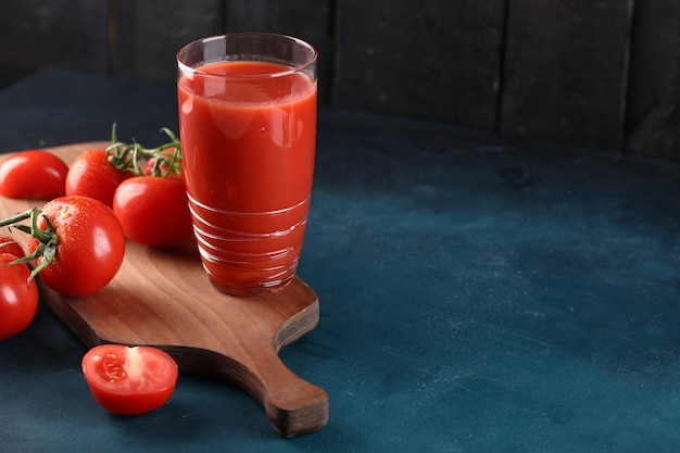 Ein glas tomatensaft, ganze und geschnittene tomaten