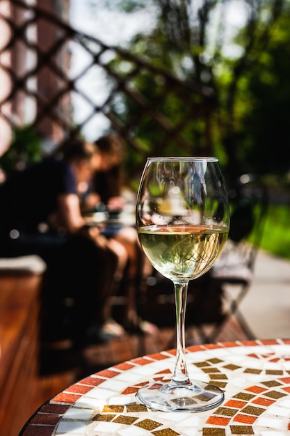 Ein Glas Weisswein Auf Einem Mosaiksteintisch Einer Kaffeeterrasse An Einem Sonnigen Premium Foto